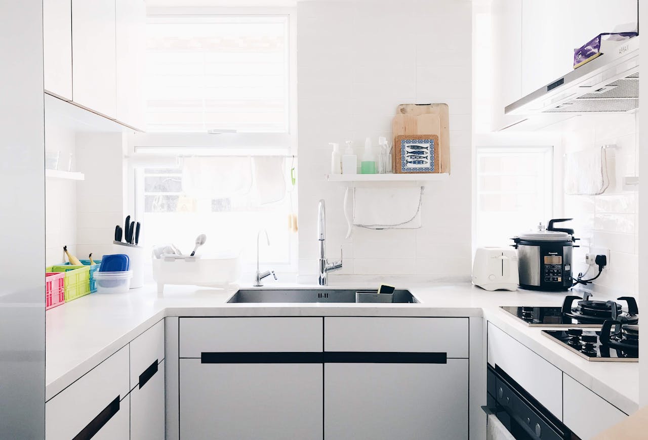 gallery-02 A clean and bright minimalist kitchen with stainless steel appliances and modern design.