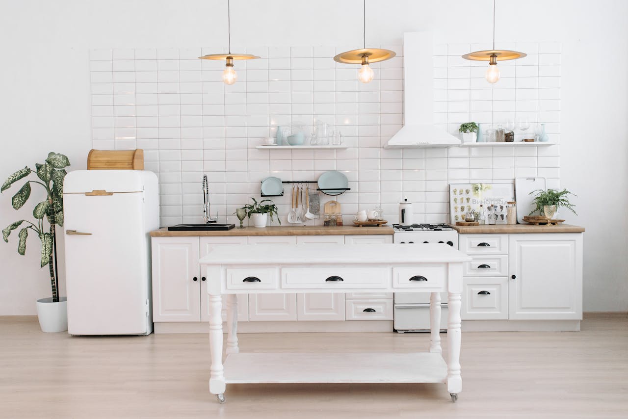 home-img A bright, minimalist kitchen with vintage appliances, plants, and pendant lights.